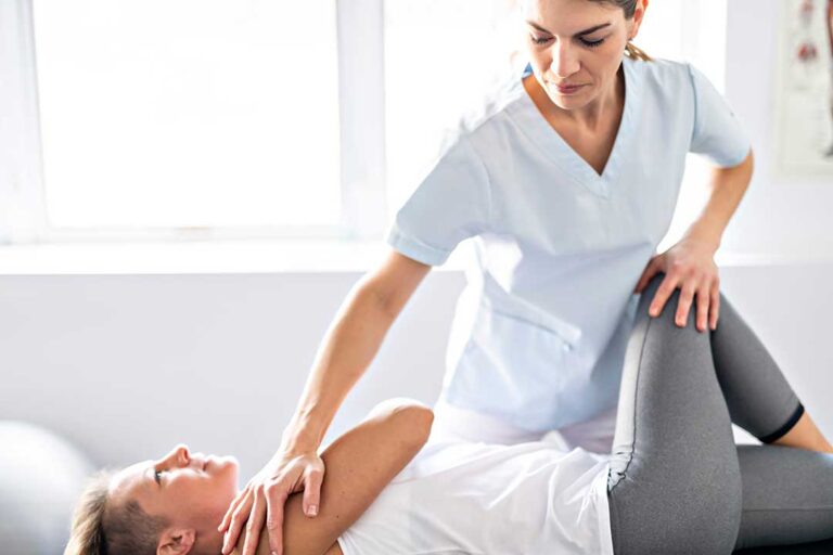 A chiropractor gently performing a manual adjustment on an adult patient's back in a clinical setting.